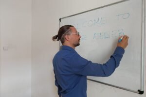 Lorenzo di Bisceglie during a language lesson. He is writing on the blackboard with a blues crayon.