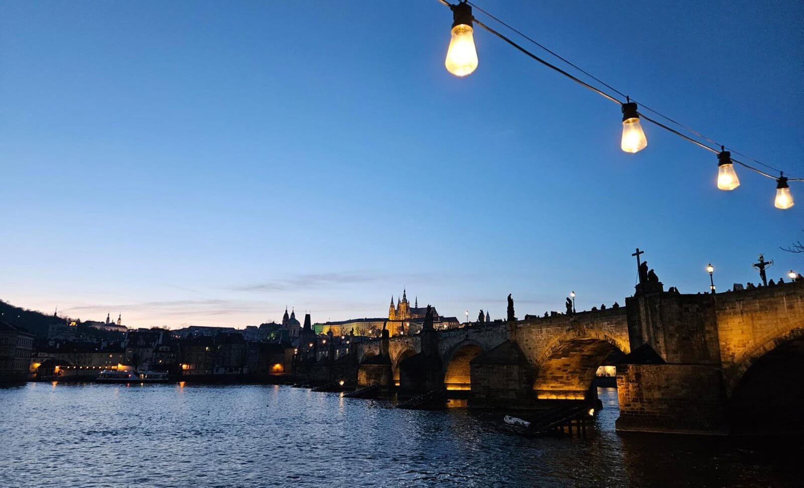 Charles Bridge and Prague Castle lit up at dusk for Czech course atmosphere