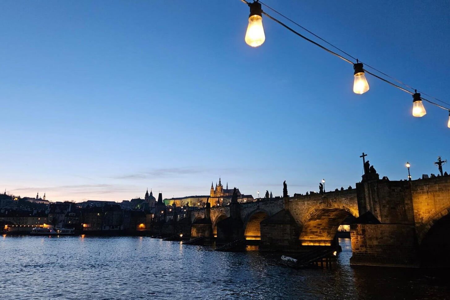 Charles Bridge and Prague Castle lit up at dusk for Czech course atmosphere