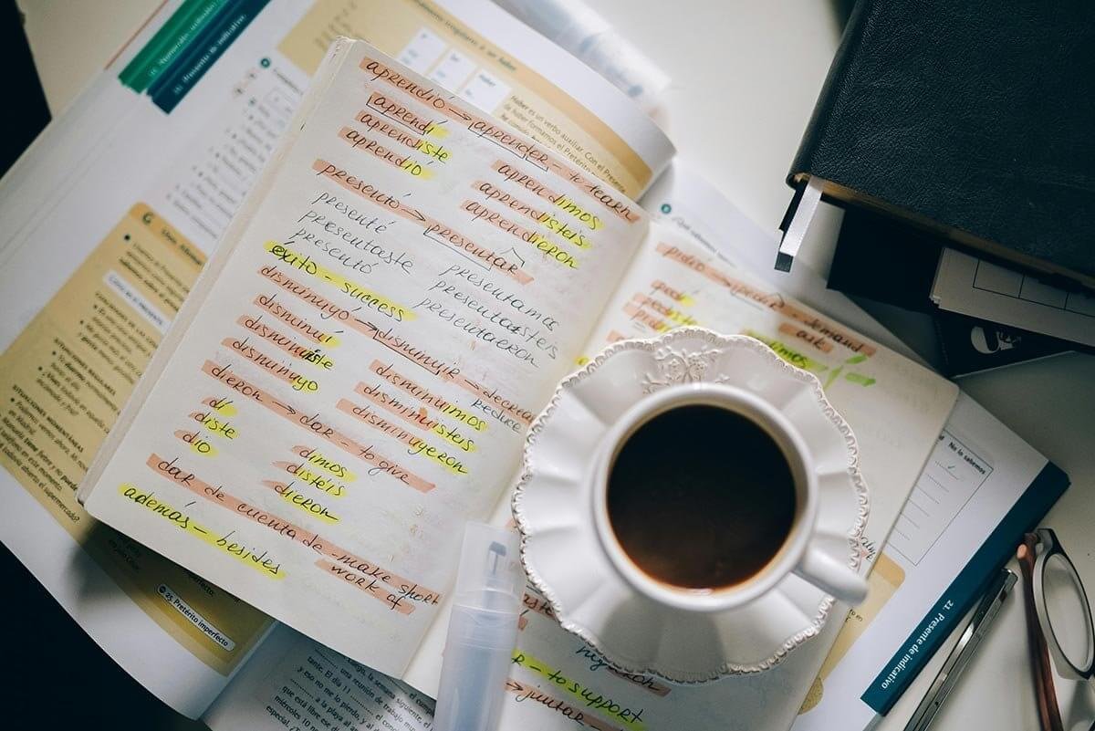 Spanish study notes with coffee cup for vocabulary learning